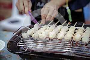 Woman hand slide meat ball that was grilled on the grilling machine