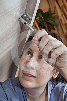 Woman hand with socket wrench tighten nut, close-up.