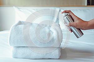 Woman Hand is Spraying Air Freshener to Towels in Bedroom, Unpleasant smell and Aromatherapy Concept