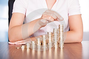 Woman hand stacking gold coin