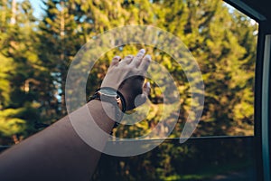 woman hand stick out of car window enjoying the wind