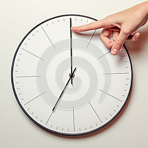 Woman hand stop time on a round clock, time management and deadline concept