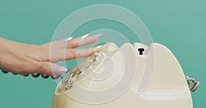 Woman, hand and studio with retro telephone, click and press buttons to dial numbers by green background. Closeup, girl