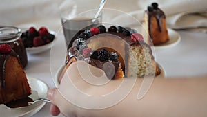 Woman hand take a piece of tasty homemade vanilla bunt cake with berries.