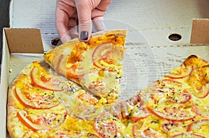 Woman hand takes a slice pizza