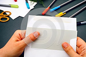 Woman hand taking out gray paper from envelope