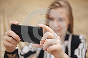 Woman hand taking photo of the city with a smartphone. Close up of woman`s hands. Cell phone. Telephone. Mobility and