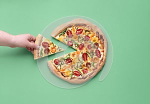 Taking pizza slice. Eating pizza primavera. Grabbing pizza photo