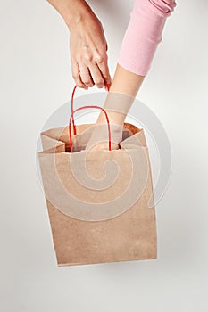 Woman hand taking present from a shopping bag