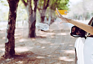 Woman hand throwing plastic bottle trash on the road,Environment and pollution campaign concept