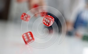 Woman hand throws red dice into air closeup