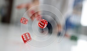 Woman hand throws red dice into air closeup