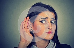 Woman with hand to ear gesture listening carefully