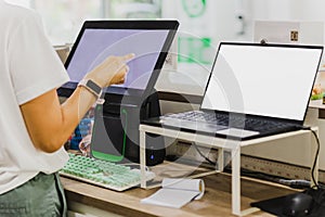 Woman hand touching computer creen at cashier counter.