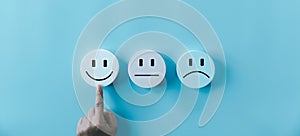 Woman hand touching happy face smile face icon on round blue object. Customer experience and service with satisfaction concept.