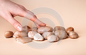 Woman hand touching small stones. Tactile sense and taction concept. Sensation and feelings from contacting smooth solid