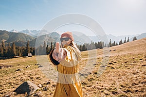 Woman hand touching virtual screen. Traveling in the mountains. Freedom, happiness, travel and vacations concept