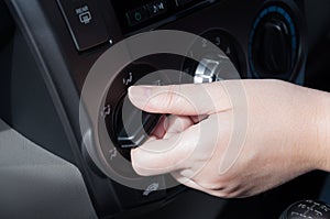 Woman hand turning on a car air conditioning system