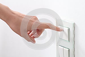 Woman hand turning operating a wall switch