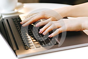 Woman hand typing on laptop keyboard