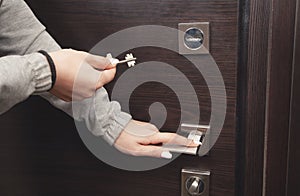 Woman hand unlocking door with key