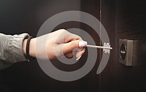 Woman hand unlocking door with key