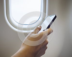 Woman Hand using cell phone in Airplane