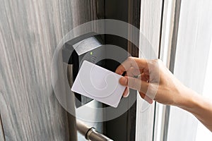 Woman hand using electronic smart key card to unlock door in hotel or house. Digital lock, door access control, contactless