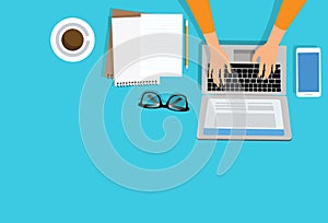 Woman hand using laptop with copy space of white working table with lnote book, pencil, smartphone, cup of coffee and eye glasses