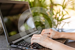 Woman hand using laptop to work study on work desk with clean nature background background. Business, financial, trade stock maket