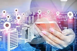 Woman hand using mobile phone with location icon over smart city ,network connection concept