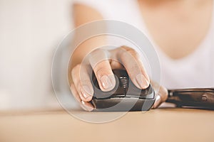 Woman hand using mouse working on computer laptop in office