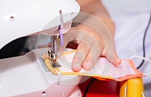 Woman hand using a sewing machine to make mask face fabric.