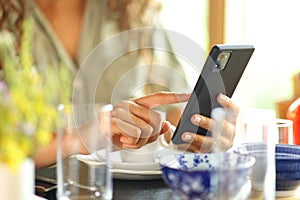 Woman hand using smart phone in a restaurant table