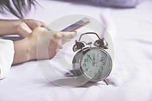 Woman hand using smartphone on bed