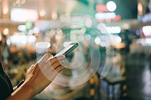 Woman hand using smartphone in mall