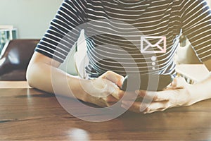 Woman hand using smartphone to send and recieve email.