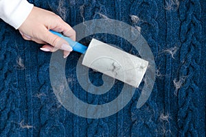 Woman hand using a sticky roller to clean fabrics