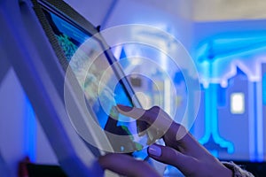 Woman hand using touchscreen display of floor standing tablet kiosk