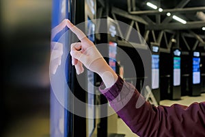 Woman hand using touchscreen display of interactive kiosk at exhibition