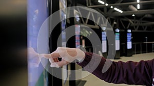 Woman hand using touchscreen display of interactive kiosk at exhibition