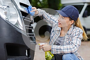 Woman hand washing car headlights