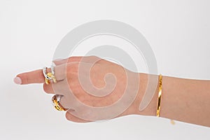 Woman hand wearing golden Snake Chain bracelet and Interlocked Golden and Silver Rings set against a white background. Beautiful