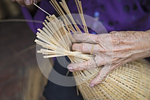 Woman hand weaving tropical bamboo fish trap in traditional crafts village in Vietnam