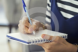 Woman hand writing check list on notebook, planning concept