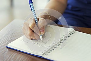 Woman hand writing check list on notebook, planning concept