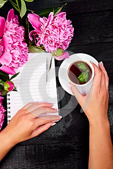 Woman hand writing diary, or letter, note with cup of coffee