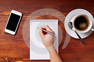Woman hand writing in a notepad