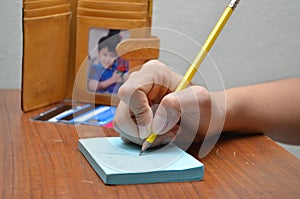 Woman hand writing on paper calculate payment of credit card stress