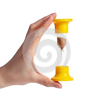 Woman hand with yellow hourglass with sand isolated on white background. Measuring time intervals concept